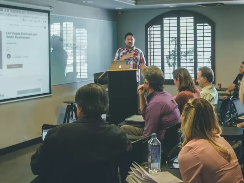 a group of people in a room with a projector screen