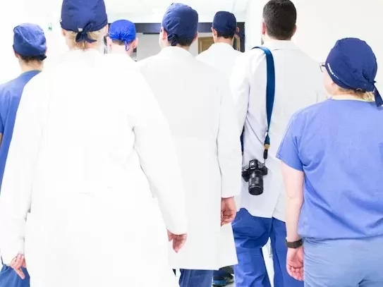 group of doctors walking on hospital hallway